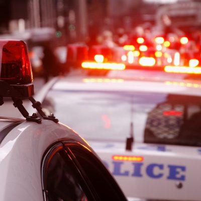 A row of police cars with flashing lights. Photographed in New York City.